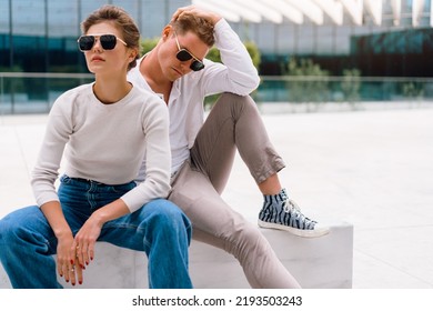 Young Couple Having Problems In Their Relationship. Man And Woman Friends In Sunglasses Sitting Bench In City Unhappy Emotions. Relationships Problem.