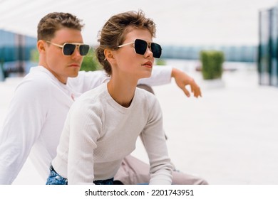 Young Couple Having Problems In Their Relationship. Man And Woman Friends In Sunglasses Sitting Bench In City Unhappy Emotions. Relationships Problem.