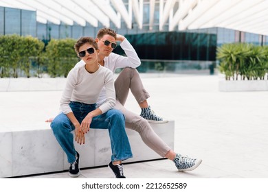 Young Couple Having Problems In Their Relationship. Man And Woman Friends In Sunglasses Sitting Bench In City Unhappy Emotions. Relationships Problem.