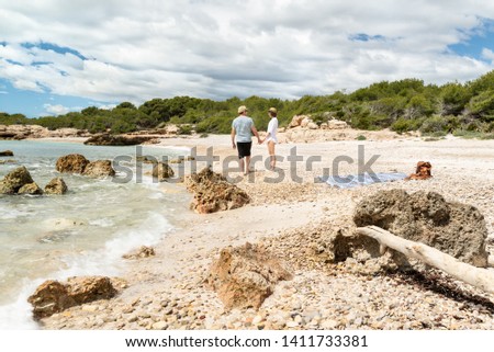 Young couple having a relaxing time at a clear water mediterranean beach. 