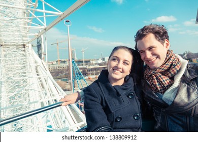 Young Couple Having A Ride On A Ferris Wheel