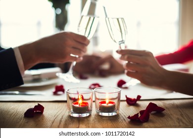 Young Couple Having Romantic Dinner In The Restaurant Drinking Champagne Cheers Close-up