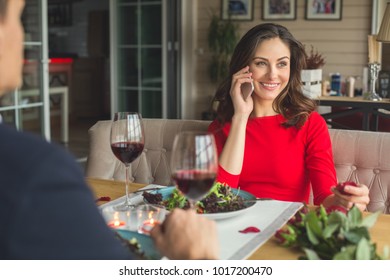 Young Couple Having Romantic Dinner In The Restaurant Phone Call Happy