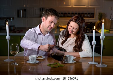 Young Couple Having Romantic Dinner On The Dinner Table At Home With Candle Light