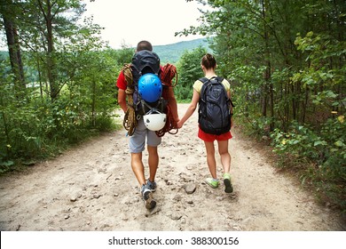 Young couple hikers in forest. sports man and woman with backpacks on road in nature - Shutterstock ID 388300156