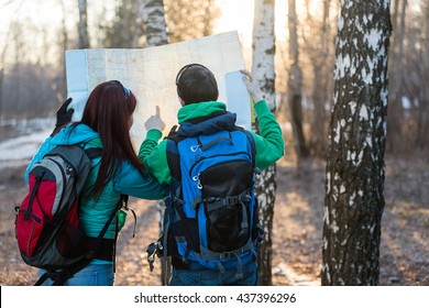 Young Couple Hikers Looking At Map.