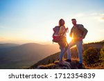 Young Couple Hiking On The Peak of Mountain drinking water