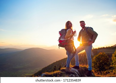 Young Couple Hiking On The Peak of Mountain drinking water