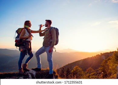 Young Couple Hiking On The Peak of Mountain drinking water - Powered by Shutterstock