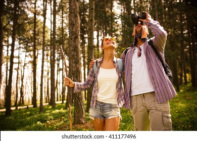 Young couple hiking trough forest and watching birds.Ornithology . - Powered by Shutterstock