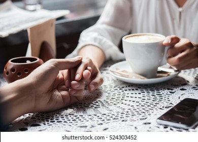 Young couple holding hands at the cafe, closeup - Powered by Shutterstock