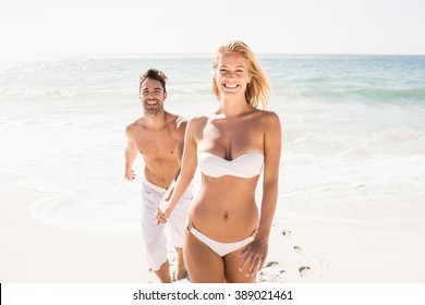 Young couple holding hands on the beach