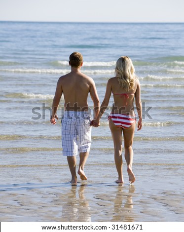 A Young Couple Holding Hands on the Beach