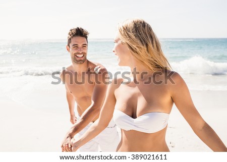 Young couple holding hands on the beach