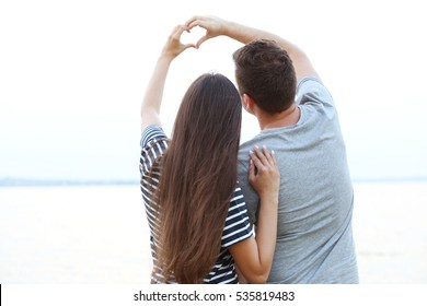 Young Couple Holding Hands In Shape Of Heart