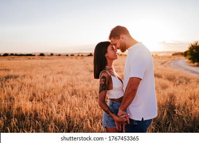young couple holding hands in a yellow field at sunset. Love and Summer time - Powered by Shutterstock