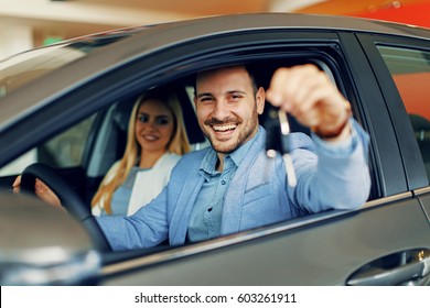 Young couple holding the keys of a new car