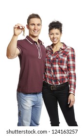 Young Couple Holding Set Of House Keys On White Background Smiling