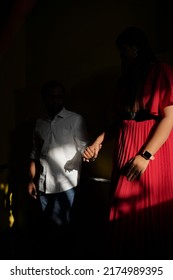           a young couple is holdinghands and standing in darkbackground."selective focus" " shallow depth of field" ' follow focus' or " blur"..