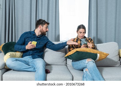 Young Couple At Home Have A Problem And Argue Due To Jealousy Caused By Chatting And Flirting Via Social Media Networks On Smart Phones, Relationship Difficulties Problems And Distrust