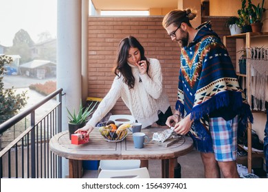 Young couple at home terrace having breakfast - togetherness, recreation, affectionate concept