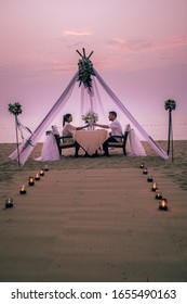 Young Couple Honeymoon Dinner By Candle Light During Sunset On The Beach, Men And Woman Having Dinner On The Beach Romantic Setting In Thailand During Sunset Pattaya