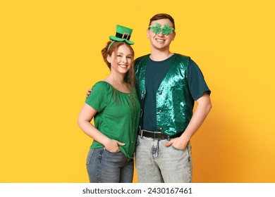 Young couple hugging on yellow background. St. Patrick's Day celebration - Powered by Shutterstock