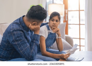 Young couple indian calculate the bill together, have serious looks, dressed in casual wear, plan their budget, paperwork, busy preparing financial report - Powered by Shutterstock