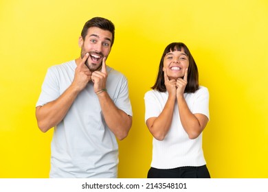 Young couple isolated on yellow background smiling with a happy and pleasant expression - Shutterstock ID 2143548101