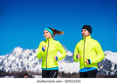 Young Couple Jogging Outside In Sunny Winter Mountains
