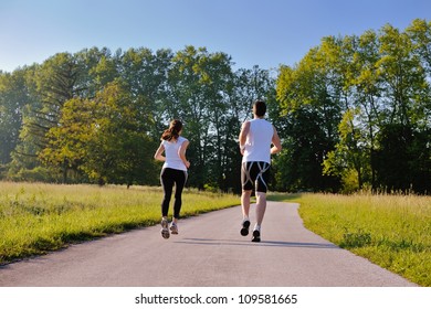 Young couple jogging in park at morning. Health and fitness. - Shutterstock ID 109581665