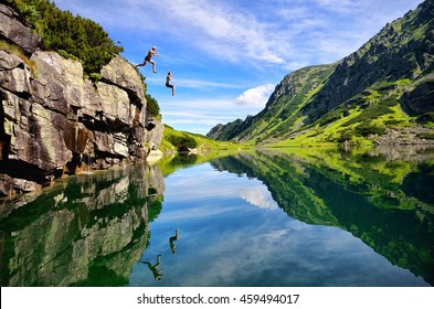 Young couple jump together into lake in mountains with beautiful blue water and reflexion.  - Shutterstock ID 459494017