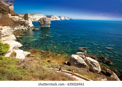 Young Couple Kayaking Near Bonifacio Town On Beautiful White Rock Cliff With Sea Bay, Corsica, France, Europe. 