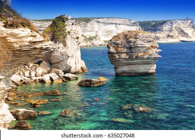 Young Couple Kayaking Near Bonifacio Town On Beautiful White Rock Cliff With Sea Bay, Corsica, France, Europe. 