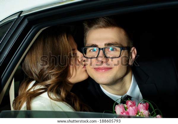 A young couple kissing in\
the car