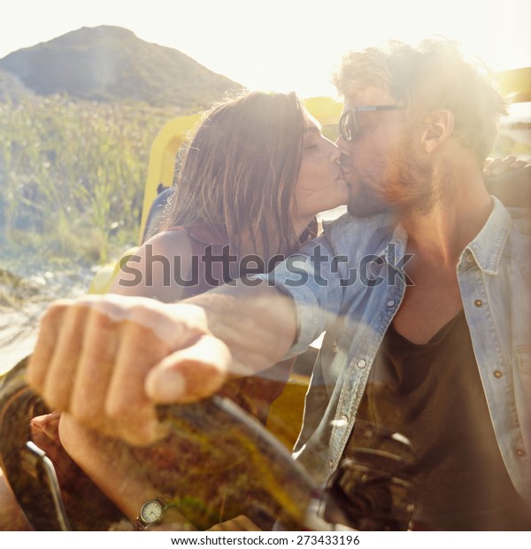 Young couple kissing in the car. Couple in love on\
road trip having fun.