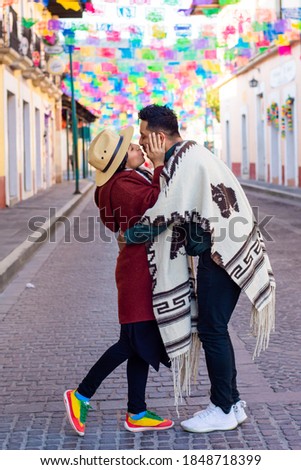 Young Couple kissing each other on colorful street