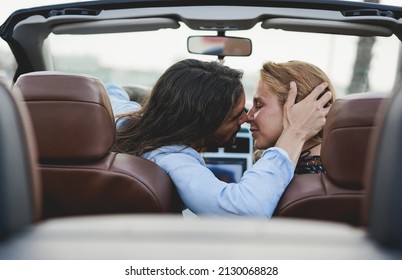 Young Couple Kissing Inside Convertible Car In Summer Vacation - Focus On Man Hand