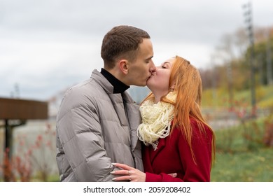 young couple kissing outdoors while walking in autumn park - Powered by Shutterstock