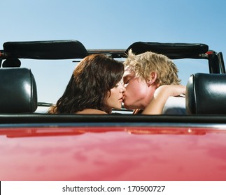 Young Couple Kissing In A Red Car