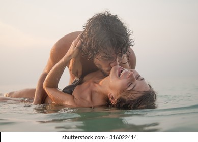 Young Couple Kissing In The Sea