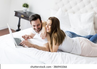 Young couple with laptop in the bed - Powered by Shutterstock