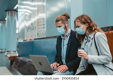 Young Couple With A Laptop On The Subway Platform .