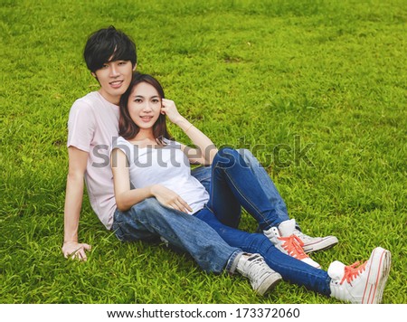 young couple laying on park 