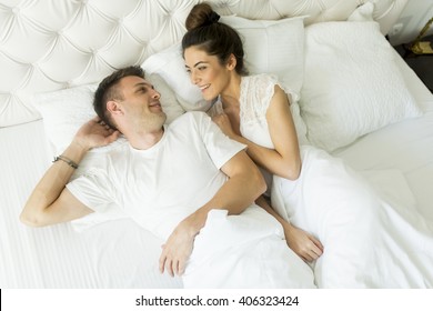 Young Couple Laying Together In The Bed