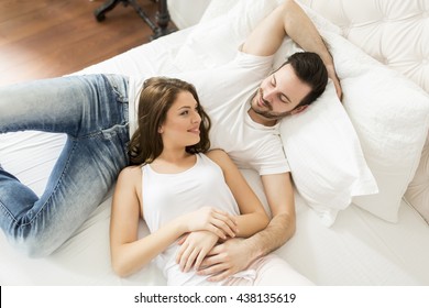 Young Couple Laying Together In The Bed