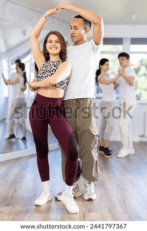 Young couple learns to dance pair disco fox during dance class in studio, repeat movements and learn act show. Studio school for amateur and professional dancers