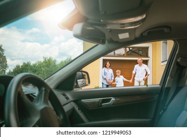 Young Couple With Little Boy Son Goes To Their New Car Standing On The New Home Yard Inside Car View