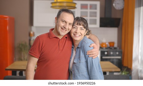 Young couple looking at each other lovingly and smiling at the camera. Happy family portrait.
