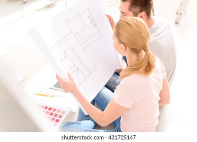 Young Couple Looking Plan Of His House